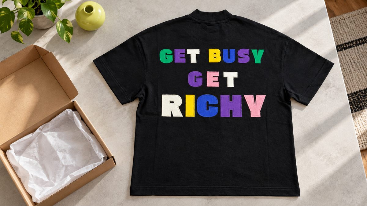 Черна тениска RICHY с цветна апликация до отворена кутия.